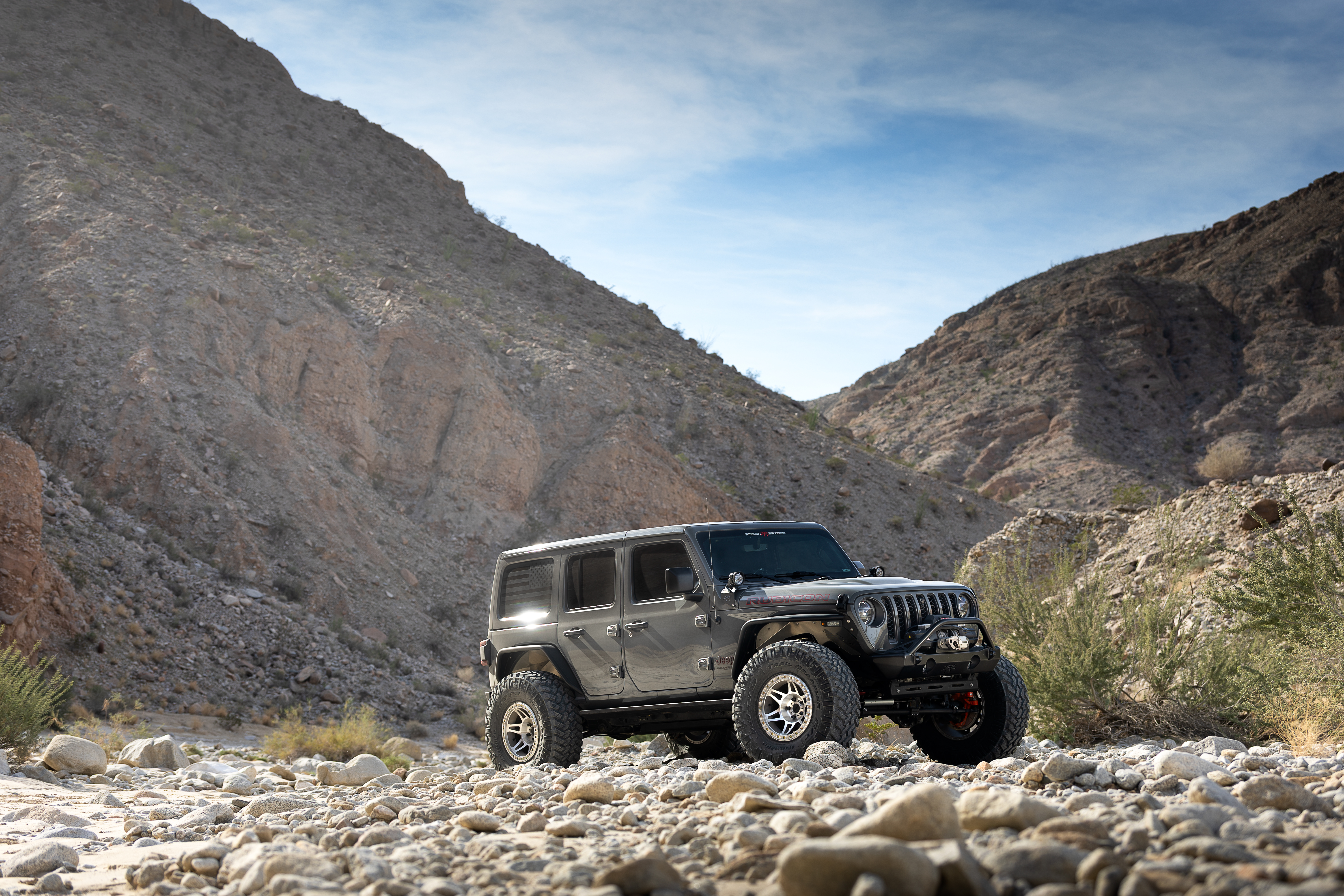 Poison Spyder Nightshade Jeep Wrangler crawling rocks in the desert
