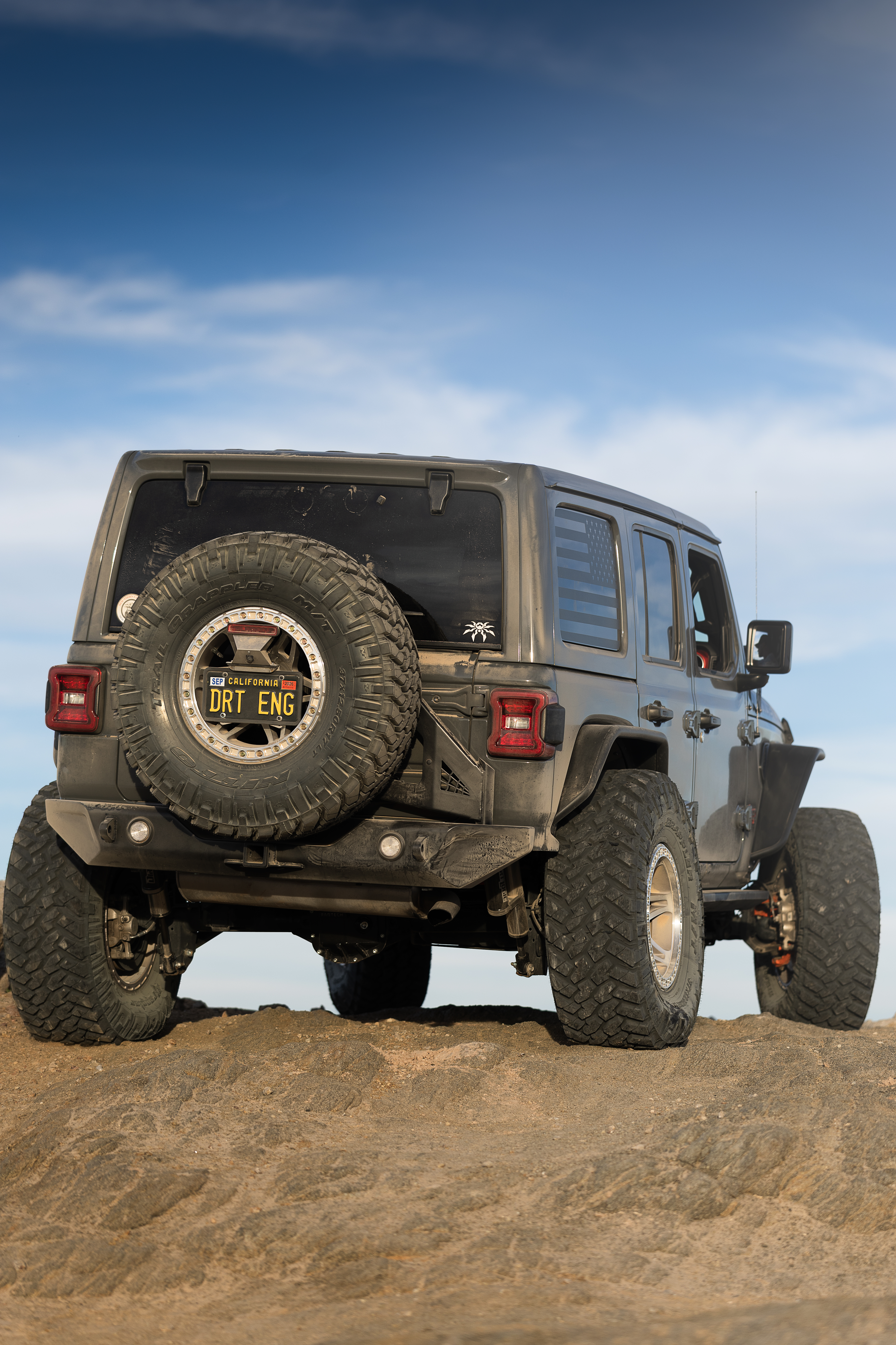 Poison Spyder Nightshade Jeep Wrangler Rubicon flexing over rocks on a trail