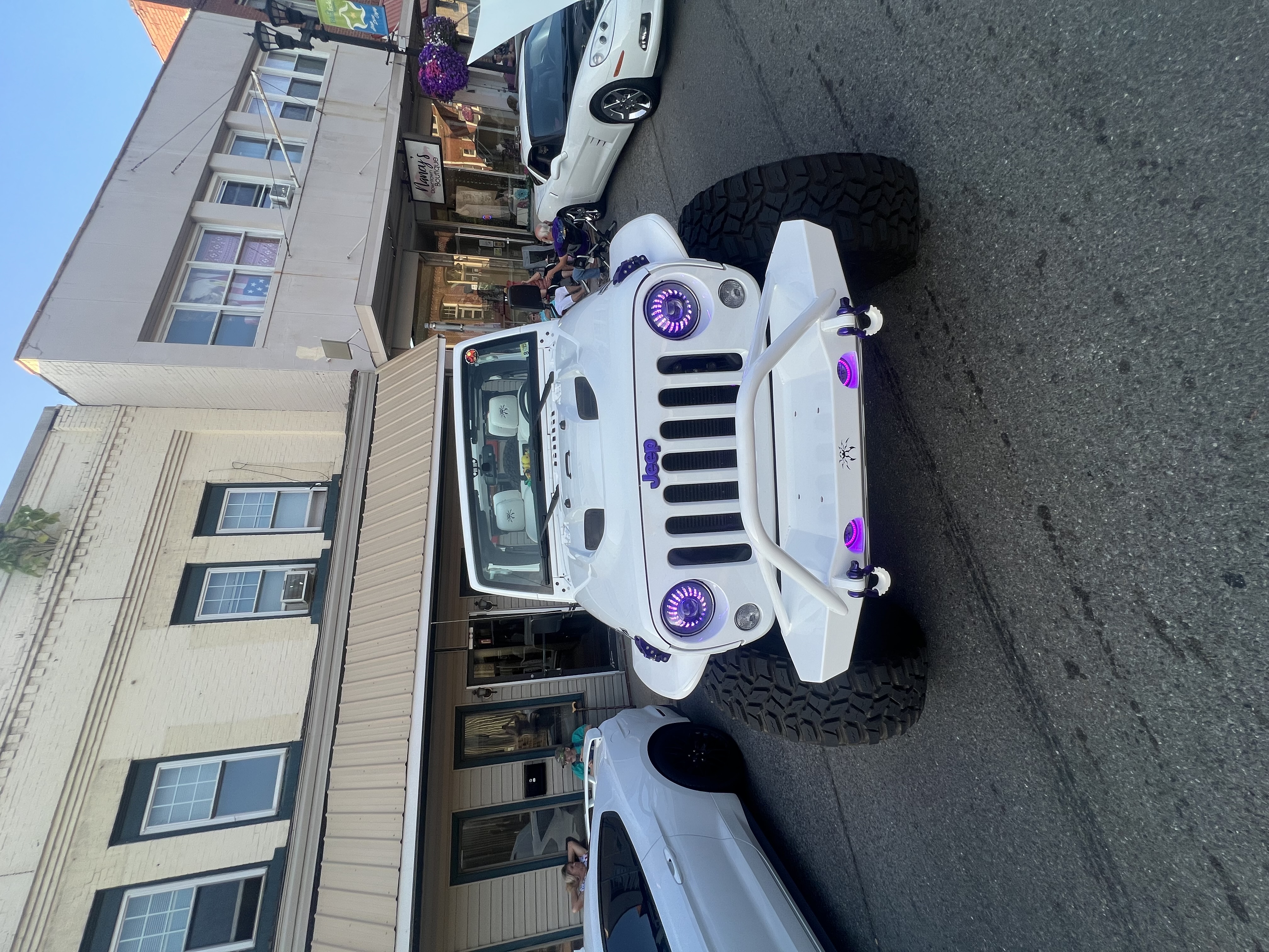 Poison Spyder White Venomous Jeep Wrangler front end with purple halo headlights at a show