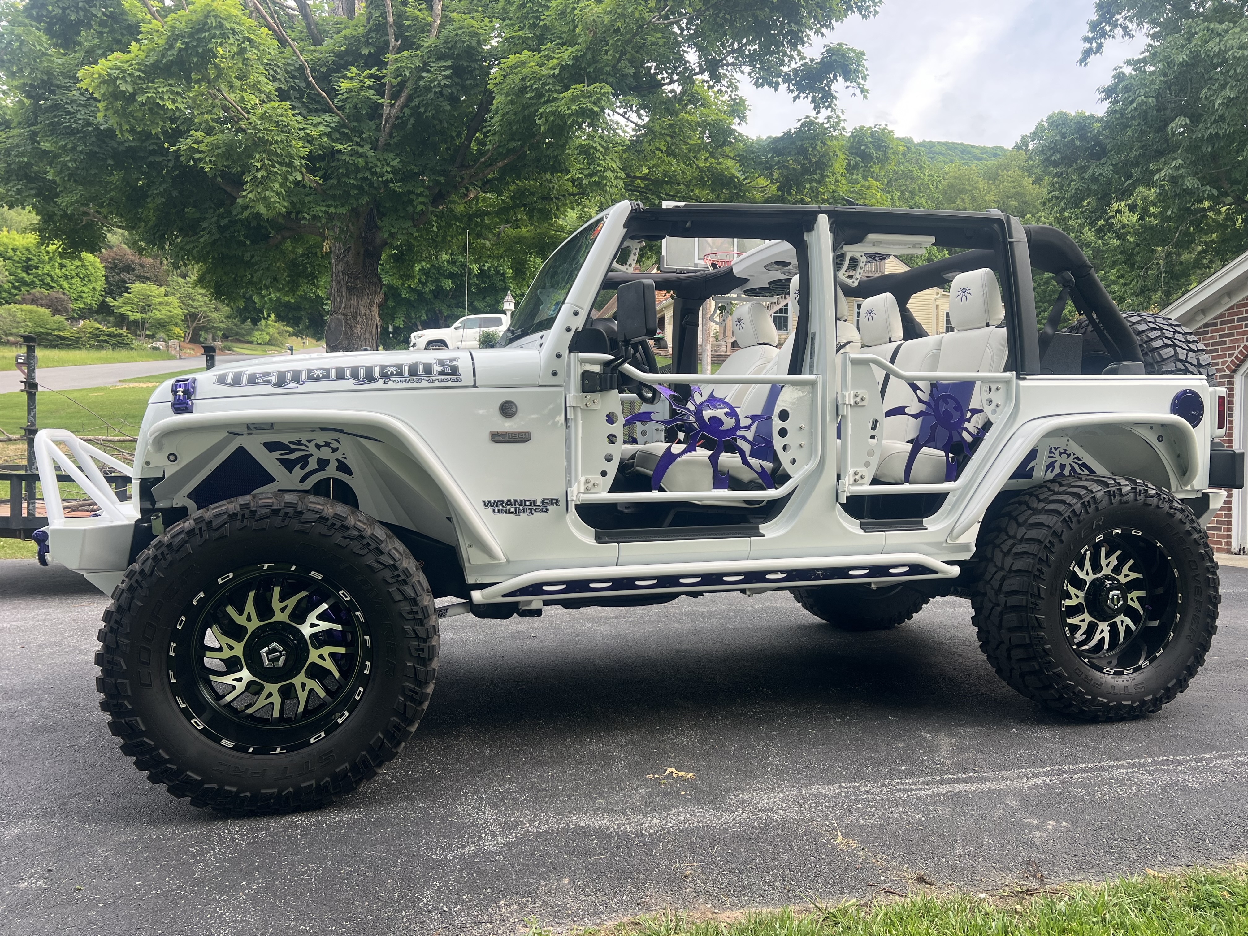 Poison Spyder White Venomous Jeep Wrangler JK Unlimited with doors off and custom purple spider graphics